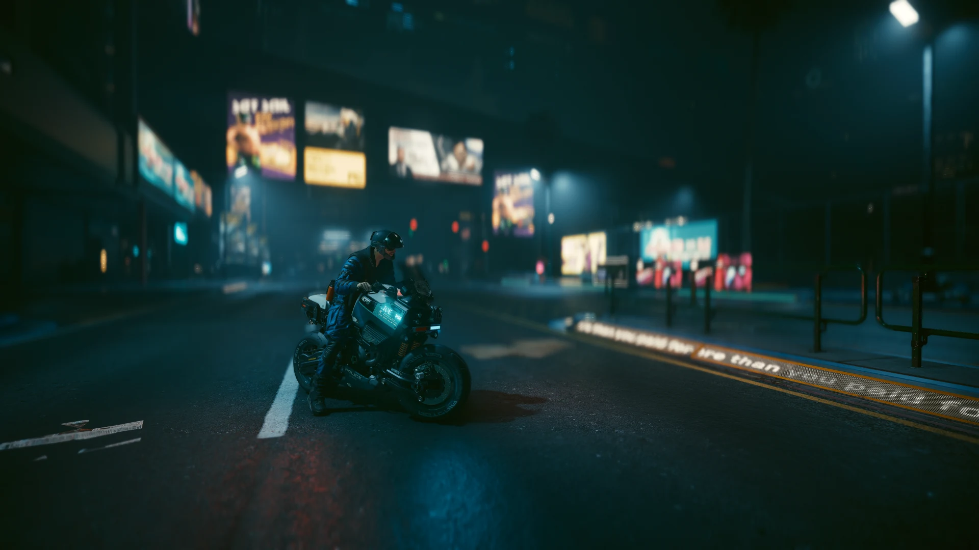 An officer on a Brennan Apollo on an empty street at night, lit billboards out of focus behind