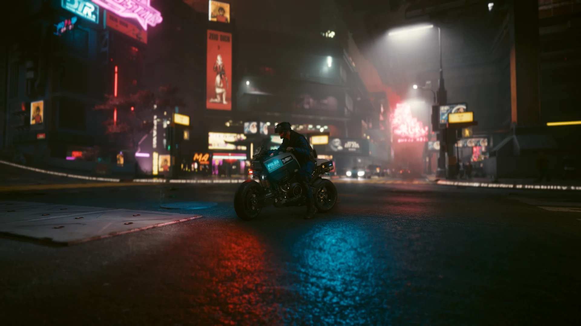 An officer on a Brennan Apollo stopped in an intersection at night, pink and red neon glowing through the fog and red and blue reflections on the wet asphalt