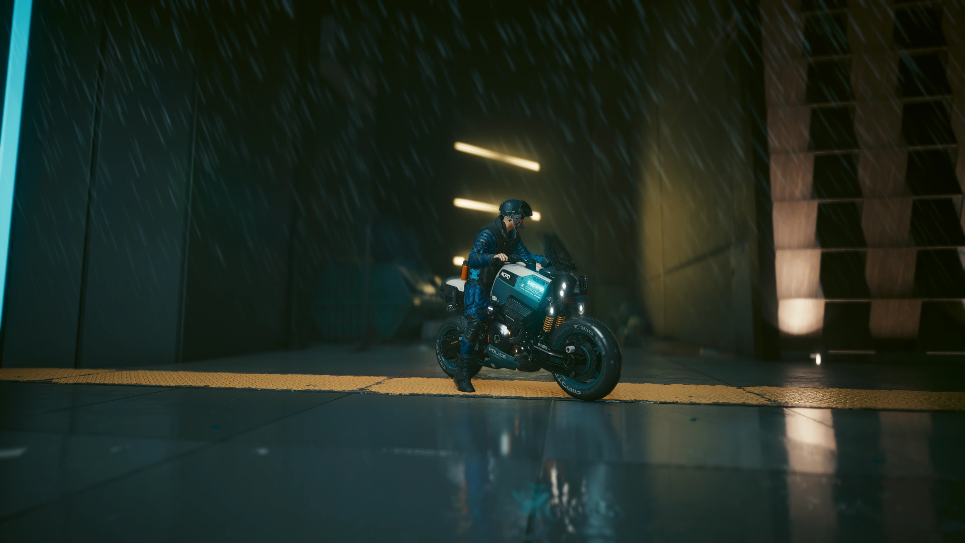 An officer stopped on a police motorcycle over a yellow hazard strip, rain falling behind