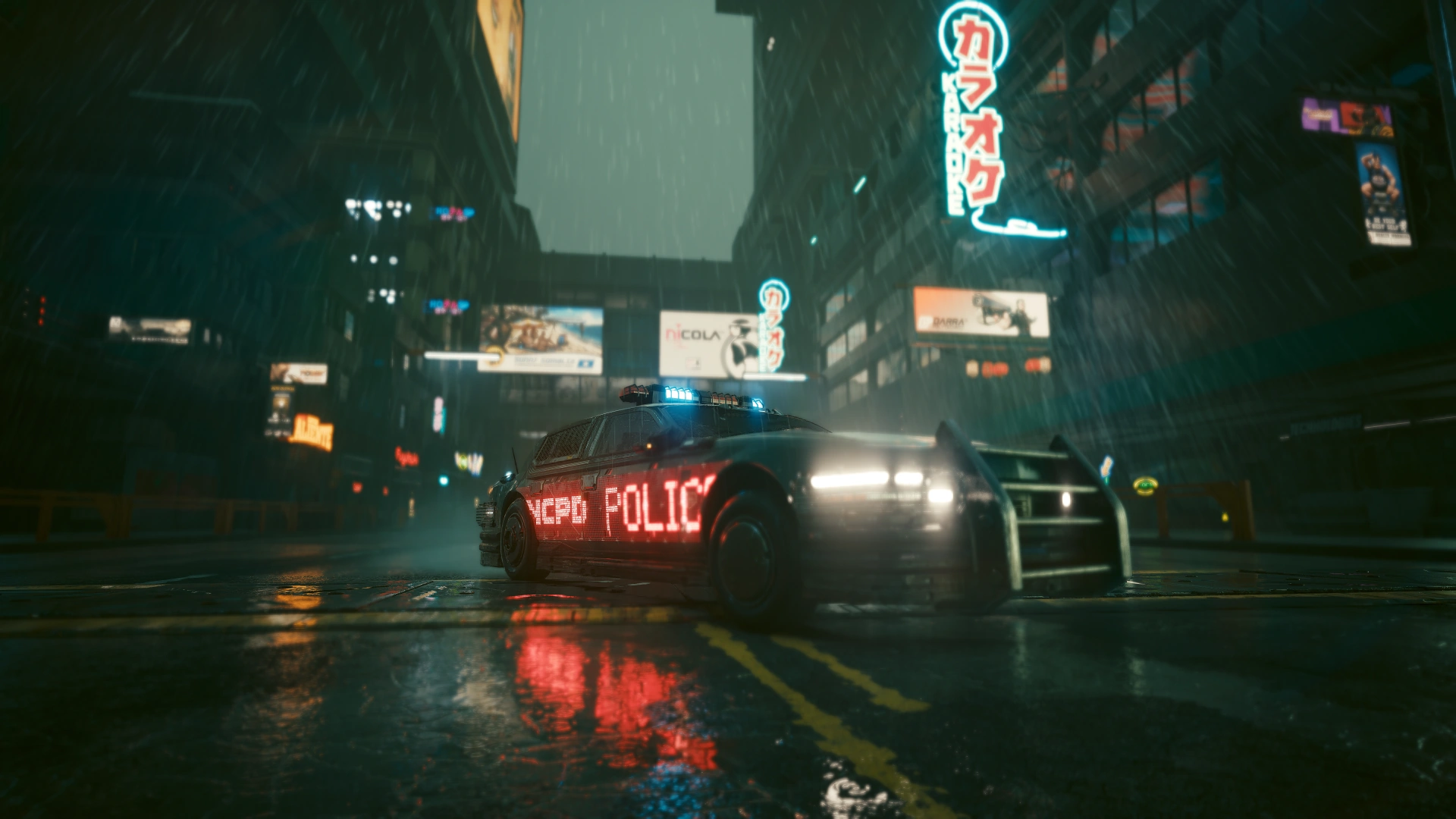 A patrol car seen from the front in the rain under a vertical karaoke neon sign, NCPD POLICE lit red along its side and the driver’s door open
