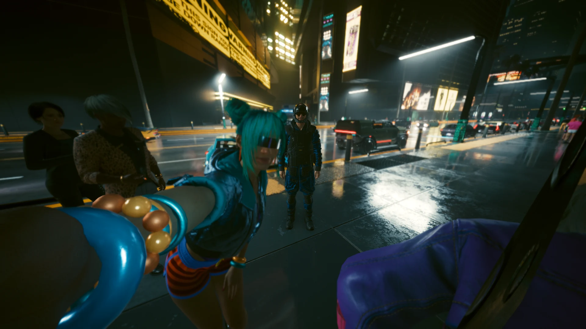 On a wet sidewalk at night, a woman with teal hair leans in for a selfie, arm stretched towards the camera, while a uniformed NCPD officer in a helmet stands behind her