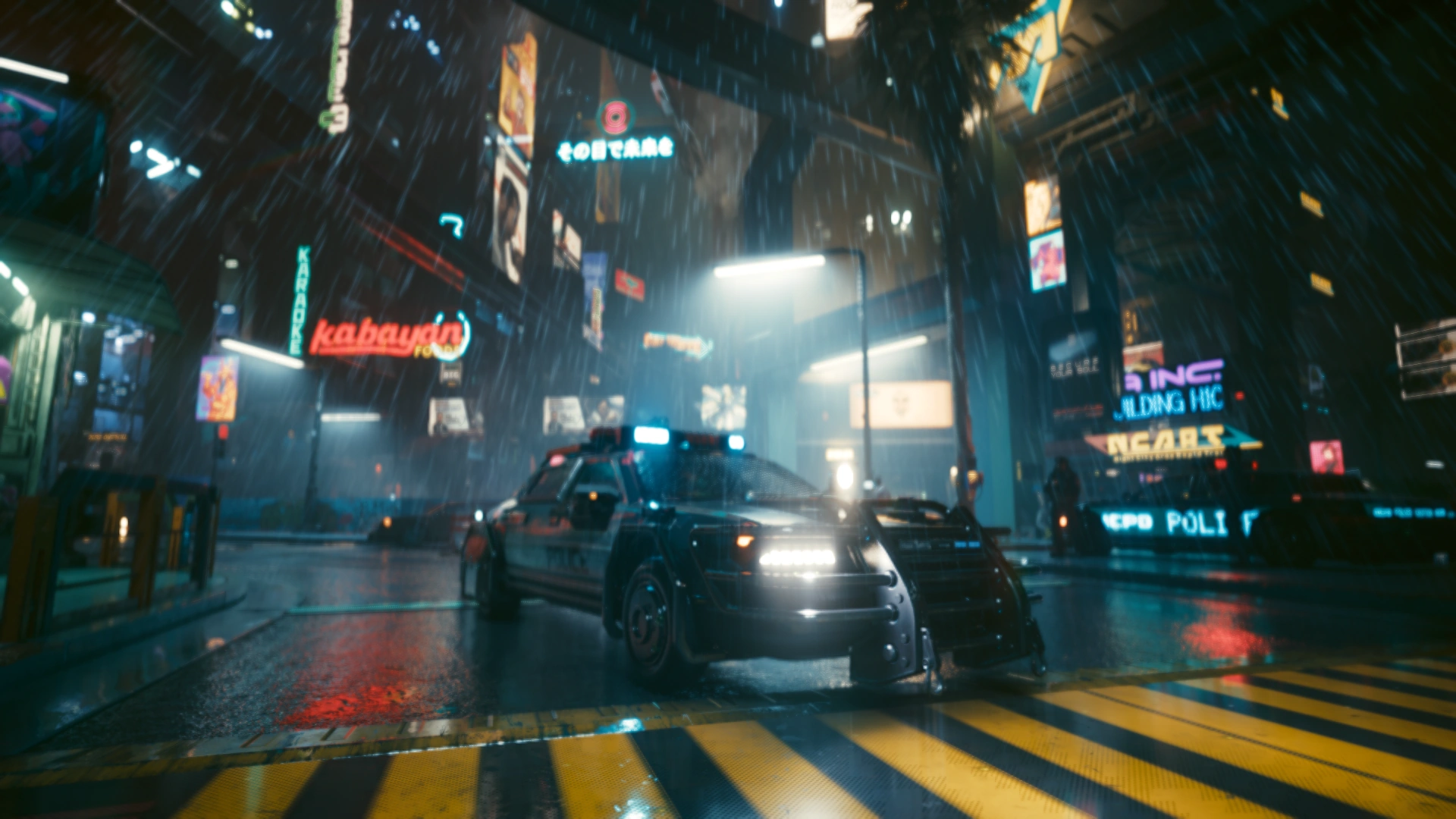A patrol car with its door open on a rain-soaked, neon-lit street at night, a second unit behind it
